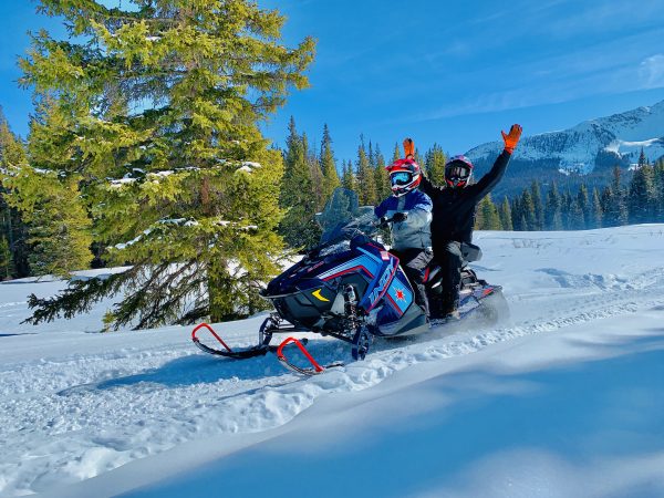 Two people on a snowmobile on the mountain